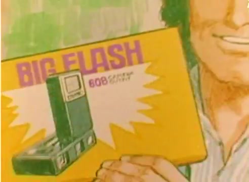 The still features a vivid illustration of a man smiling while holding a colorful box labeled 'BIG FLASH' alongside an image of a camera. The box emphasizes the product’s features with bursts of excitement, indicative of a promotional style typical of sales films from the late 1970s. The context suggests it's part of a Kodak sales film intended to showcase innovative products leading into the 1977 Christmas season. The overall aesthetic is bright and engaging, fitting the era's marketing trends.