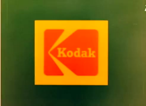 This still features the iconic Kodak logo against a green background. It serves as part of the 1977 sales film associated with the Christmas marketing campaign. As a 16mm silent negative, it emphasizes Kodak's branding and visual identity during that period. The absence of dialogue allows the imagery to focus on the nostalgic and promotional aspects of Kodak's film products.
