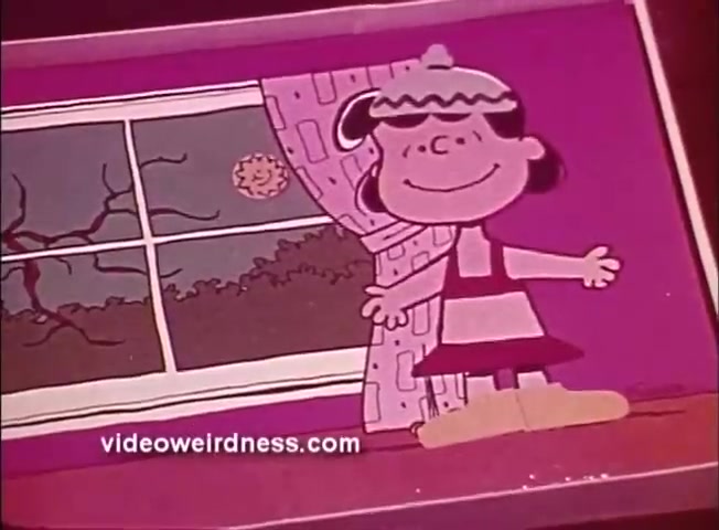 The still features Lucy from the Peanuts cartoon, standing cheerfully in front of a window. She has a big smile and is wearing a dress with a contrasting color pattern. Behind her, the window shows a sunny scene with a smiling sun and some barren branches outside, suggesting a bright day. The overall color scheme is vibrant, fitting the playful tone of the 'Colorforms Peanuts' series.