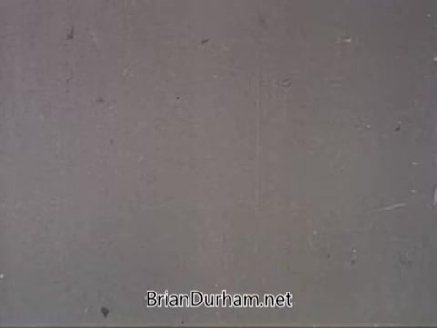 The still from the 'American Medical Association PSA - 1960s' features a plain, textured background that appears to be slightly worn, likely from the film's age. The overall tone is neutral, and there are minimal visual distractions, suggesting a focus on the message intended by the PSA. The lack of prominent imagery points toward a straightforward communication style typical of public service announcements from that era.