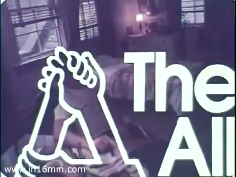 The still features a bedroom setting with a person lying in bed, suggesting a sense of introspection or contemplation. Prominently displayed is a graphic of two hands gripping each other, symbolizing support and solidarity. The text 'The All' appears, likely indicating a message of unity and encouragement, reflecting the PSA's theme of helping veterans transition into the workforce. The overall tone combines a sense of urgency and optimism.