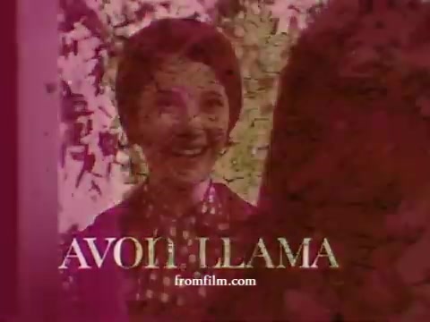 The still from 'Avon Llama (Avon Calling)' features a cheerful woman with short hair, smiling broadly. She appears to be engaged in a conversation, possibly promoting Avon products. The colors are warm, with a vintage aesthetic typical of 1970s film. The title 'AVON LLAMA' is prominently displayed at the bottom in stylized lettering, hinting at the playful and quirky nature of the content.