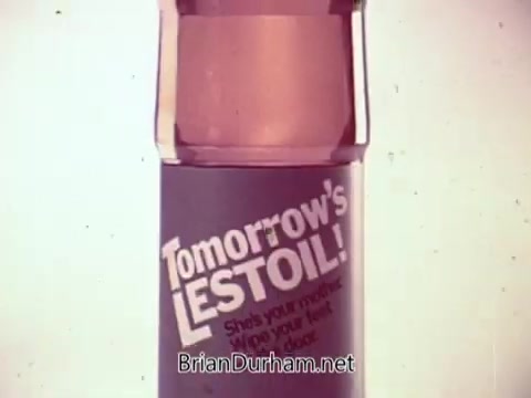 The still showcases a bottle of Tomorrow's Lestoil cleaner prominently displayed against a simple background. The bottle is transparent, revealing a pinkish liquid inside. Bold text on the label reads 'Tomorrow's LESTOIL!' along with a tagline highlighting its cleaning capabilities. The overall presentation is colorful and upbeat, typical of a musical television commercial, aimed at promoting the product's effectiveness in household cleaning.