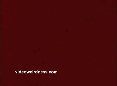 The still features a red background with visible grain and texture, typical of a 16mm film print. The text 'videoweirdness.com' is displayed in the lower left corner, indicating the source of the image. The overall appearance suggests a vintage and artistic take on promotional content for the Unity Church, featuring Joe Campanella.