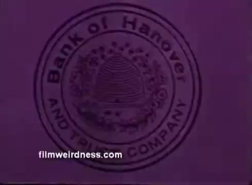 The still features a circular logo of the 'Bank of Hanover and Trust Company.' The design includes an illustration of a beehive, surrounded by decorative elements. The overall color scheme is a muted purple, giving it a vintage appearance typical of program sponsorship bumpers from earlier television or film eras. The text is clearly visible, emphasizing the bank's name and its role as a sponsor.
