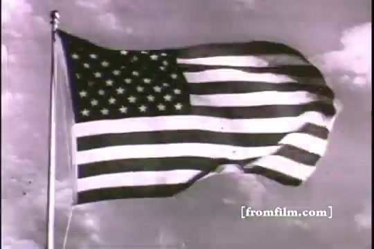 The still features a waving American flag set against a cloudy sky. The flag displays its iconic stars and stripes, symbolizing patriotism and national pride. This image likely represents themes of military service and recruitment in the context of the film 'Great Moments in History.' The composition emphasizes the motion of the flag, suggesting a call to action or duty.