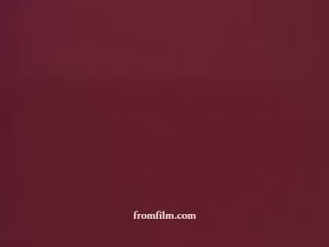 The still from 'Seagram's 100 Pipers Scotch (Spanish)' features a deep burgundy background, typical of vintage advertising aesthetics. The simplicity of the image suggests a focus on the elegant branding associated with the scotch, conveying a classic and refined feel. No additional visual elements are present in this shot.