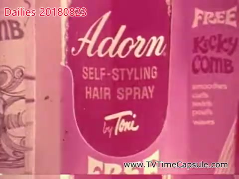 The still features a close-up of a product labeled 'Adorn Self-Styling Hair Spray by Toni.' The packaging is predominantly pink, with distinct lettering. It also advertises a 'Free Kicky Comb' alongside other details, suggesting a marketing focus on hair styling products. The vintage aesthetic is typical of mid-20th century advertisements.