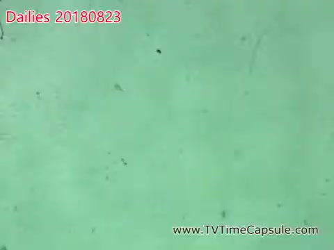 The still appears to be from a 16mm film, showing a textured, greenish surface. It may feature minor imperfections, such as scratches or debris, which are characteristic of older film stock. The title at the top indicates it's part of daily footage dated August 23, 2018, likely involving a project associated with the name 'Scott' and towels. The composition suggests a focus on close-up details or an experimental shot.