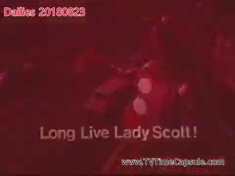 The still features a vibrant red background with text that reads 'Long Live Lady Scott!' It appears to be from a video or film labeled 'dailies 20180823-scott-towels-etc,' indicating it captures a moment of celebration or tribute. The imagery suggests a lively atmosphere, possibly associated with a performance or event dedicated to Lady Scott.