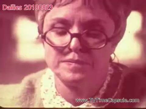 The still from 'dailies 20180823-scott-towels-etc' depicts an older woman with glasses, showing a thoughtful or contemplative expression. She wears a light-colored shirt with a lace collar, and the image has a vintage, slightly faded look typical of 16mm film. The focus seems to be on her face, suggesting an emotional moment or significant dialogue.