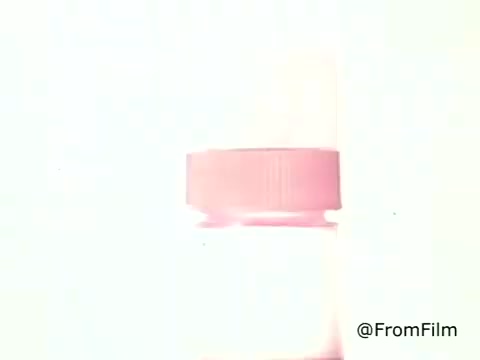 This still features a bottle of Golden Griddle Pancake Syrup, characterized by its distinctive pink cap. The image has a bright, washed-out quality typical of 1970s film, emphasizing a nostalgic aesthetic. This style often conveys warmth and comfort, connecting back to family breakfasts. The simplicity of the focus highlights the syrup as the central element, evoking a sense of home and classic dining experiences.    for more vintage content.