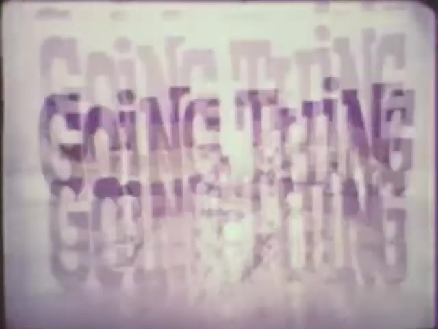 The still features the text 'GOING THING' prominently displayed in a layered, overlapping style. The letters are rendered in a slightly blurred manner, creating a sense of depth and motion. The color palette is soft, possibly featuring pastel hues, contributing to a vintage aesthetic. The composition suggests a dynamic and creative video project, likely emphasizing the theme of progression or movement.