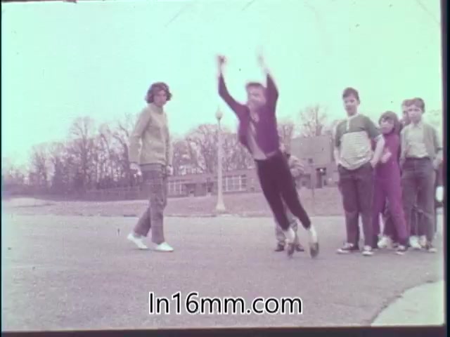 The still from the 'Special Fitness Awards PSA - 1968' features a group of children at a park. One child is leaping into the air, showcasing physical activity, while a girl watches on the left. The mood reflects encouragement and participation in fitness activities, typical of public service announcements promoting health and exercise among youth during that era.