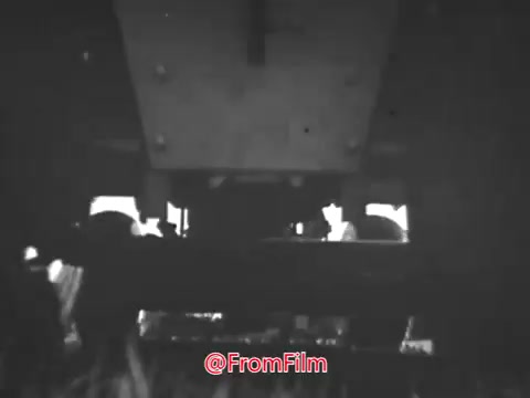 The still from the 'Massey Ferguson Lawn Tractor' commercial featuring Jerry Colonna depicts a close-up view from beneath the tractor, showcasing its wheels and undercarriage. The black-and-white imagery emphasizes the mechanical details of the lawn tractor, likely highlighting its strong build and functionality. The commercial represents the 1960s advertising style, focusing on the product's reliability and efficiency. For licensing information and higher resolution files, please contact the source.