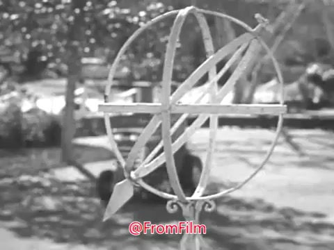The still from the Massey Ferguson lawn tractor commercial featuring Jerry Colonna showcases a garden setting with an ornamental globe or armillary sphere prominently displayed in the foreground. In the background, a Massey Ferguson lawn tractor is visible, highlighting the product's integration into a serene outdoor environment typical of the 1960s. The overall composition emphasizes both the charm of the garden and the appeal of the lawn tractor as a practical tool for homeowners.   If you wish to use this footage for your project, options for licensing and acquiring a higher resolution digital file are available. The current available format is SD at 720x480 in a DV codec .AVI file.