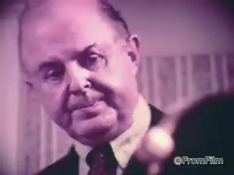 The still features a man with a serious expression, closely examining something off-camera. His focus suggests a moment of contemplation or concern regarding the item he's observing. The background is softly blurred, highlighting the man and enhancing the serious tone. The context relates to a commercial for Baggies alligator storage bags, emphasizing protection against freezer burn, portrayed in a catchy, memorable manner.