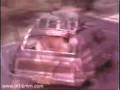 The still from the 1975 PSA 'Join the PTA' features a vintage vehicle, likely a station wagon, driving along a rugged road. The image has a faded quality typical of 16mm film, with a warm color palette. The scene emphasizes a familial or community aspect, suggesting a connection to local involvement and engagement, which aligns with the PTA's mission. The vehicle's movement conveys a sense of adventure or journey, reinforcing themes of participation and support in community activities.