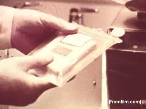The still features a close-up of a person's hands holding a packaged loaf of Pepperidge Farm bread. The packaging appears simple and functional, suggesting a focus on the bread's preservation for space travel. The background includes elements of a spacecraft environment, reinforcing the commercial's connection to NASA's Apollo missions. The overall aesthetic evokes a nostalgic feel, highlighting the integration of everyday products into extraordinary contexts.