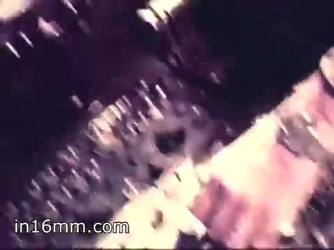 The still from 'Air Force Reserve Recruiting - 1968 - Air Crews' depicts a close-up view of equipment, likely from an aircraft cockpit or control panel. The image captures various dials, switches, and gauges, highlighting the technical aspects of aircrew responsibilities. The color tone appears to be slightly muted, characteristic of that era's film stock, suggesting a focus on the intricacies of aviation technology and the experience of being part of an air crew.