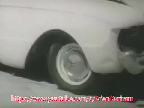 The still from the 'Underwater Car PSA - 1969' features a partially submerged automobile with its wheels visible. The image likely captures the moment just after the car has plunged into water, illustrating the dramatic situation. The context provided in the voice-over serves as a precautionary message about drowning in vehicles, advising viewers to stay calm and escape through a window, as cars initially float before sinking. The emphasis is on safety and proper response in emergencies.