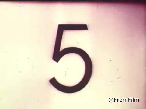 The still depicts a large, bold number '5' against a simple, light background. This frame is likely from a countdown segment in the 1960s Chase and Sanborn Coffee commercial featuring race car driver Roger McClusky in Las Vegas. The visual emphasis on the number indicates it might be building anticipation or transitioning to an action sequence. The vintage aesthetic is characteristic of mid-20th century advertising.