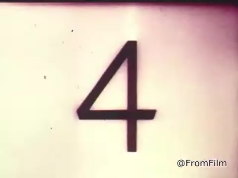The still shows a large number '4' on a white background, possibly indicating a countdown or a segment marker in the commercial. It's from a 1960s Chase and Sandborn coffee advertisement featuring race car driver Roger McClusky, hinting at a dynamic and possibly exciting context related to racing and coffee consumption. The image reflects the vintage style of 16mm film prints from that era.