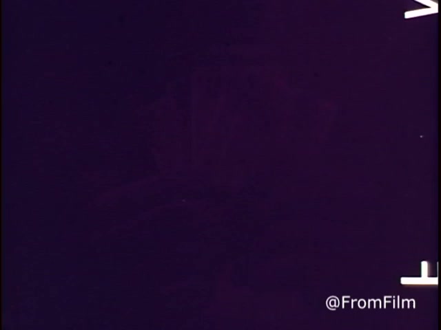 The still is a frame from a 1970s animated M&M's commercial titled 'Go Fish.' It features M&M's chocolate candies, specifically showcasing plain and peanut varieties. The ad emphasizes 'good, clean fun' and includes a red M&M character, indicating it was produced before 1976, when the red dye was discontinued. The overall tone captures a playful, nostalgic feel typical of that era's commercials.