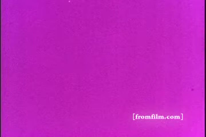 The still features a solid purple background, indicative of a vintage print quality typical of 16mm films. It likely represents a transitional or filler frame from the 1970s Exlax laxative commercial. The simplicity of the background suggests it could be used to attract attention or emphasize a message that would follow.