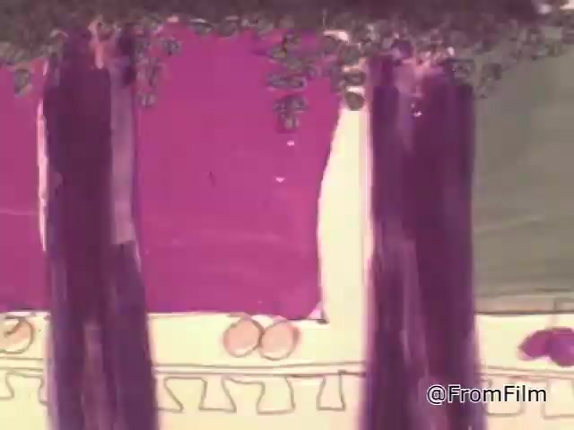 The still from the 1967 'Christmas Seals PSA' presents a colorful, hand-drawn animation style typical of mid-20th century public service announcements. The image features vibrant purples and greens, set against a simple decorative background with shapes that suggest festive elements. This artwork likely aimed to convey a cheerful and inviting holiday spirit while promoting the cause of the National Tuberculosis Association through the sale of Christmas seals. The 16mm print quality adds a nostalgic feel, capturing the essence of its time. For collectors, the original seals from this era are still available today.   Follow @FromFilm for more insights!