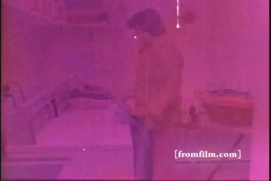 The still features a man standing in a laundry room, surrounded by washing machines and folded clothes. The image has a notable pink tint, typical of aged 16mm prints. The scene likely emphasizes the ease of use and effectiveness of Lestoil detergent, common in 1970s advertisements.