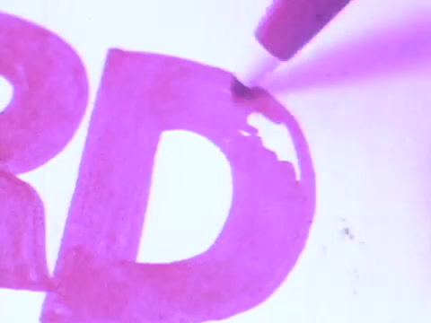 The still from the 'Flair Pens' commercial features a close-up of a magenta pen marking a bold letter 'D' on paper. The vibrant color emphasizes the product's ink quality and precision. The tagline suggests the pen's design prevents mushing, ideal for clear and definitive writing. The depiction showcases the creative potential of Flair Pens, targeting both artistic and practical uses.   For more, follow us on Twitter @FromFilm.