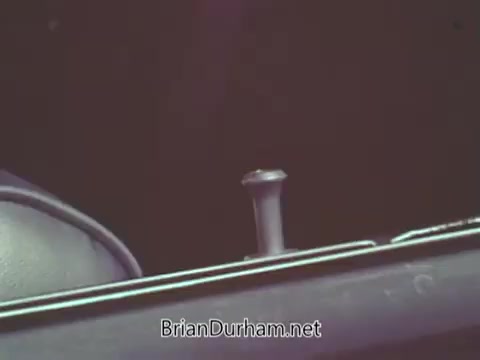 The still from the 'Automotive Safety Foundation PSA' features a close-up view of a car's interior, focusing on a part of the dashboard or control panel. There are elements suggesting safety features, possibly highlighting the importance of car safety in the context of the PSA. The lighting is dim, contributing to a serious tone, typical of public service announcements from that era aimed at promoting awareness of automotive safety.