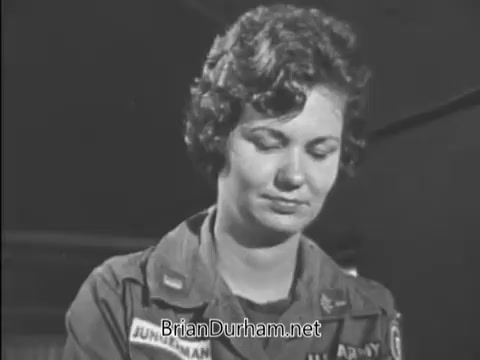 The still features a woman in a military uniform with a patch, likely from the Army, looking down thoughtfully. The image appears to convey a serious or contemplative mood, fitting the context of a PSA promoting bond purchases during the Vietnam Era in 1968. The focus on the individual suggests a personal connection to the message.