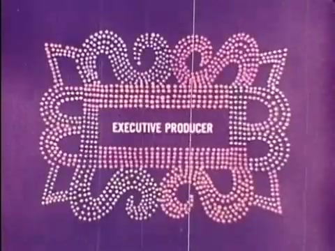 The still features a decorative title card from the 'Rocky and Bullwinkle Show,' showcasing the credit for 'EXECUTIVE PRODUCER' against a vibrant purple background. The design is comprised of intricate, swirling patterns made up of small, light-colored dots, conveying a whimsical and classic animation style typical of the show's aesthetic. This 16mm print captures the charm of vintage animated credits.   Subscribe, like or follow us on Twitter @FromFilm.