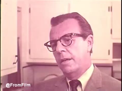The still from the 'Cold Power Detergent TV Commercial - 1960s' features a man in a suit and glasses, expressing concern or contemplation. The kitchen setting suggests a domestic theme, typical for advertisements of that era. His serious demeanor contrasts with the upbeat tone usually associated with detergent commercials, highlighting the importance of effective cleaning. This scene captures the essence of 1960s advertising, focusing on family and household products.  Follow us on Twitter at @FromFilm.