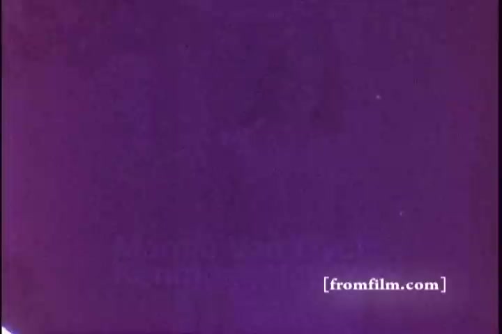 The still depicts a monochromatic purple background with faint textures, typical of aged 16mm film. It potentially features text or imagery related to an Ivory Soap commercial from the 1970s, although specific details are not clearly legible. The overall aesthetic captures the essence of retro advertising.