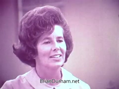 The still features a woman with voluminous, styled hair, smiling and appearing engaged in conversation. The image has a vintage quality, consistent with a 16mm film, and is likely from a commercial promoting Cold Power detergent. The setting appears light and casual, typical of mid-20th century advertising.