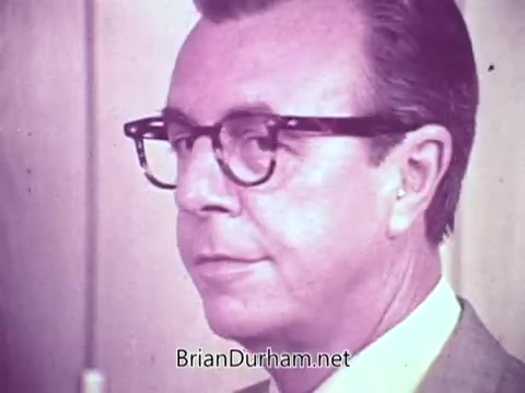 The still features a man wearing glasses, with a neutral expression, likely in a domestic or promotional setting. The background suggests a typical interior environment, possibly a kitchen. This image is from a Cold Power detergent commercial filmed in Fort Myers, Florida, promoting the product's effectiveness.