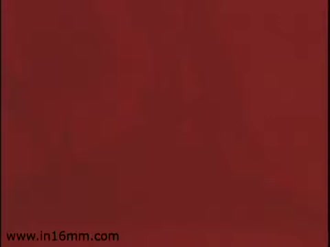 The still from 'Klik and Kam Lunch Meat' features a solid red background, likely stylized to evoke the color associated with the lunch meat products being advertised. The visual simplicity suggests a focus on branding, possibly aiming to create a strong visual association with the Klik and Kam products. The use of 16mm film indicates a vintage aesthetic, typical of promotional materials from the 1970s.