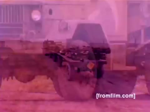 The still from the 'USMC Aviation Ordnance enlistment film' showcases a montage of military aircraft, specifically highlighting the F-4 Phantom, AH-1 SuperCobra, FA-18, and Harrier. It depicts scenes of ordnance being mounted, with a focus on missiles and bombs being loaded onto these aircraft. The color appears washed out, typical of a 16mm negative, and could benefit from better correction for a more accurate portrayal of the original film's vibrancy. The overall atmosphere suggests a professional military environment focused on aviation ordnance.