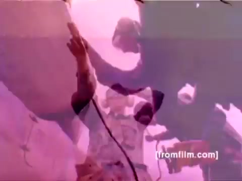 The still from the 'USMC Aviation Ordnance enlistment film' depicts military personnel engaged in the mounting of ordnance on aircraft. Key elements include F-4 Phantoms, AH-1 SuperCobras, an FA-18, and a Harrier being prepped with missiles and bombs. The scene captures the technical and operational aspects of aviation ordnance, emphasizing the importance of these roles in the Marine Corps. Color correction applied to the 16mm negative enhances clarity and detail, bringing a more vivid representation of the subjects and their environment.