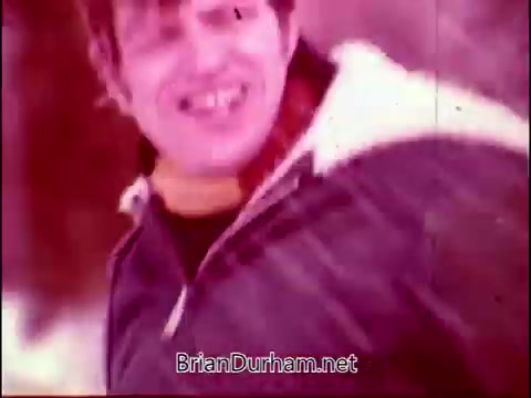 The still appears to capture a moment of dynamic energy, featuring a smiling man in a casual jacket, possibly engaged in an outdoor activity. The color palette has a warm, nostalgic quality, typical of 16mm film. The context ties back to 'Campbell's Soup - The Manhandlers,' with a theme song by Frankie Laine, suggesting a lively or humorous connection to the product. Overall, it evokes a sense of fun and adventure.