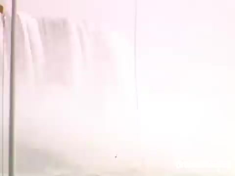 The still features a misty view of Niagara Falls, capturing the powerful cascade of water. The scene is likely part of a nostalgic home movie from 1948-1950, emphasizing the iconic natural beauty and grandeur of the falls during that era. The soft focus and light color palette evoke a sense of memory and reflection.
