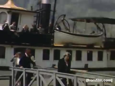 The still from 'Home Movies: Rochester/Niagara Falls 1948-1950' depicts a group of people disembarking from a steamboat at a dock. The vessel features a traditional design, with passengers enjoying the scenic view. This snapshot captures a moment of leisure, reflecting post-war Americana and the popular tourism of the era around Niagara Falls. The color and style of the film evoke a nostalgic, vintage feel typical of mid-20th century home movie footage.