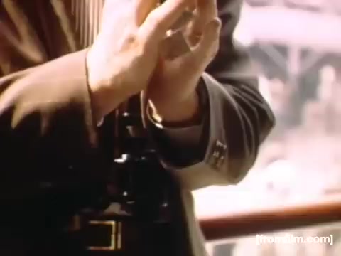 The still features a close-up of a man's hands holding a camera, likely in a setting that emphasizes capturing moments. The attire suggests a mid-20th century style, indicative of the time period between 1948 and 1950. The background hints at an outdoor or scenic location, possibly related to Rochester or Niagara Falls, reflecting the personal and familial themes of the film. The warm color tones contribute to a nostalgic atmosphere.