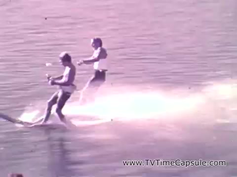 The still from the political advertisement features two individuals water skiing on a serene body of water, emphasizing recreational opportunities. The image aligns with the voiceover's message about the benefits of infrastructure projects, highlighting clean water and new jobs for Missouri citizens. The vibrant activity symbolizes enjoyment and community engagement, underpinning Stuart Symington's dedication to improving local quality of life.