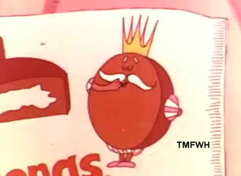The still features a cartoon character named King Ding Dong, who appears as a round, chocolate-colored pastry with a crown. He has a playful expression, with a handlebar mustache and is holding one hand to his mouth, suggesting a whimsical or cheeky demeanor. The background is colorful, typical of the 1970s aesthetic, and includes branding related to the Hostess Ding Dongs, a popular snack. The overall vibe is nostalgic and humorous, reflecting the quirky style of commercials from that era.