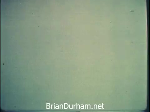 The still from the 1968 Niagara Rolla-ssage chair commercial features a minimalist, faded background, emphasizing the importance of relaxation amidst the chaos of work and decision-making. The narrative highlights the chair as a comfort solution for busy individuals, suggesting that self-care is crucial for those who perform significant tasks. The tone is urgent yet reassuring, promoting the idea that investing in personal comfort is worthwhile.