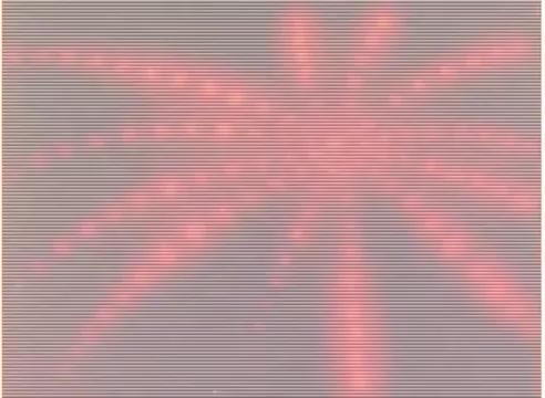 The still from the 16mm negative shows a vibrant, abstract design resembling a burst or explosion, characterized by radial lines and a pink hue. The image captures a dynamic, animated quality that may reflect the playful and imaginative style typical of animation associated with 'Sesame Street,' possibly representing energy or celebration. The background appears muted, enhancing the striking visual elements in the foreground.